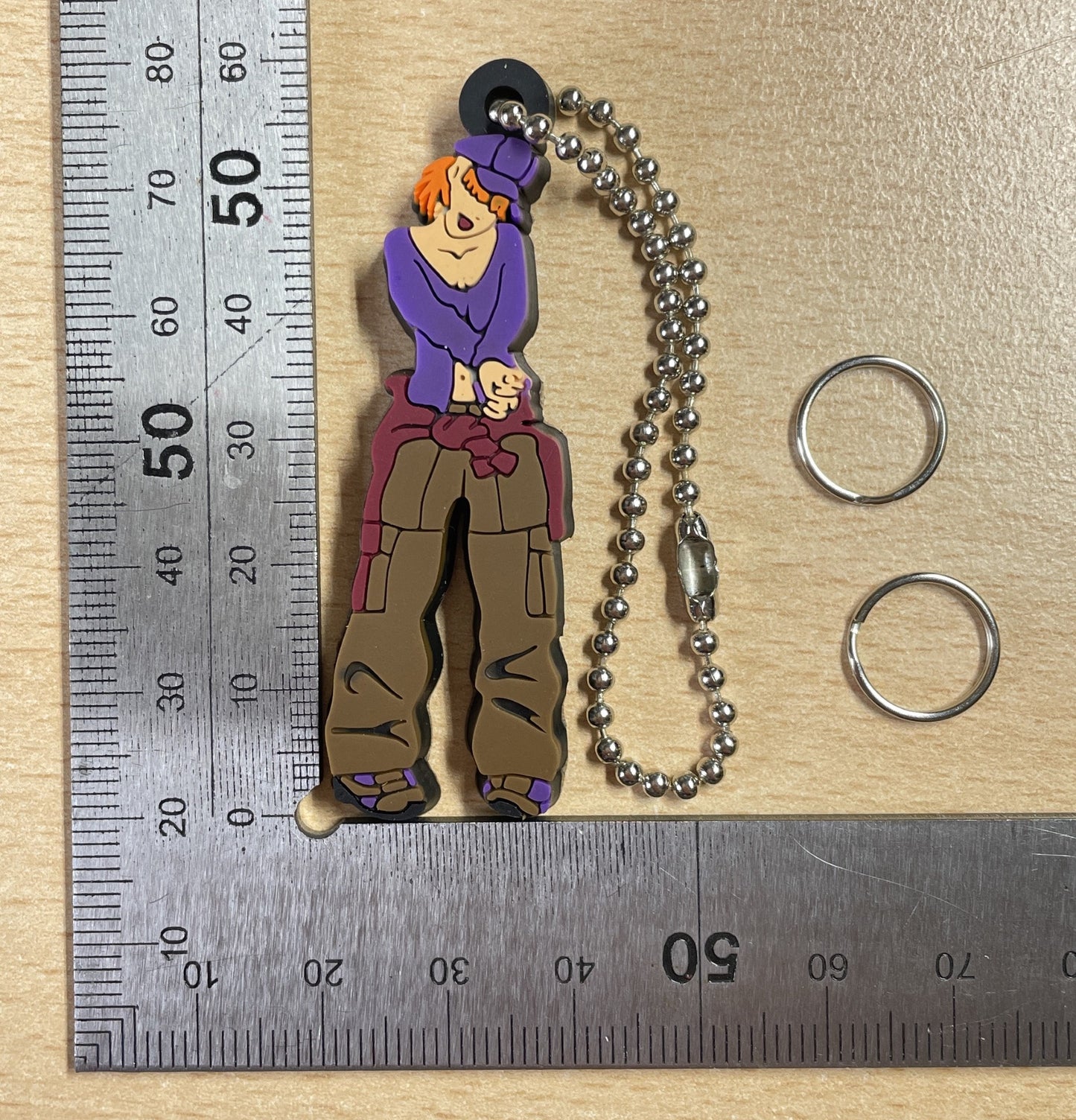 Keychain Charm girl with orange hair, wearing a purple shirt