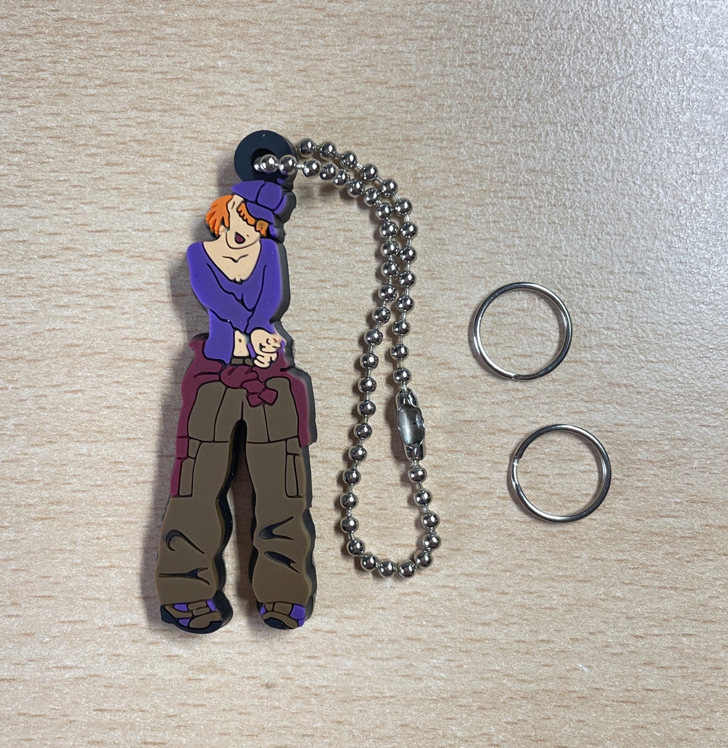 Keychain Charm girl with orange hair, wearing a purple shirt